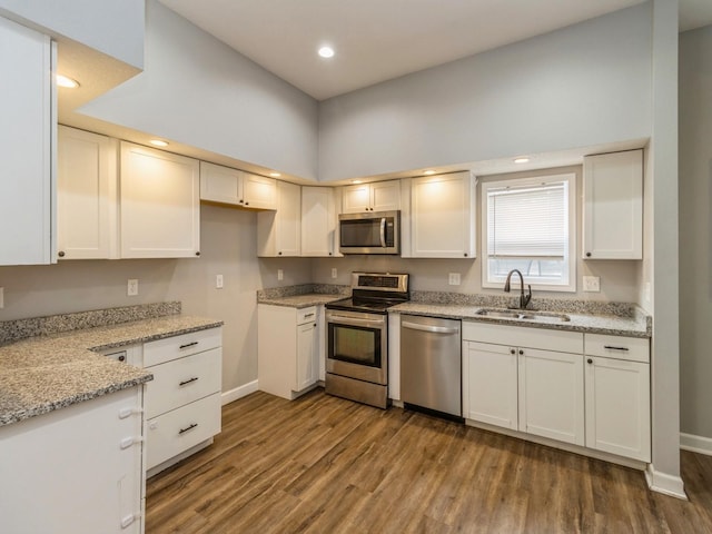 601 S 3rd Ave E, Newton, IA 50208 - kitchen with stainless steel appliances, a sink, wood finished floors, baseboards, and recessed lighting