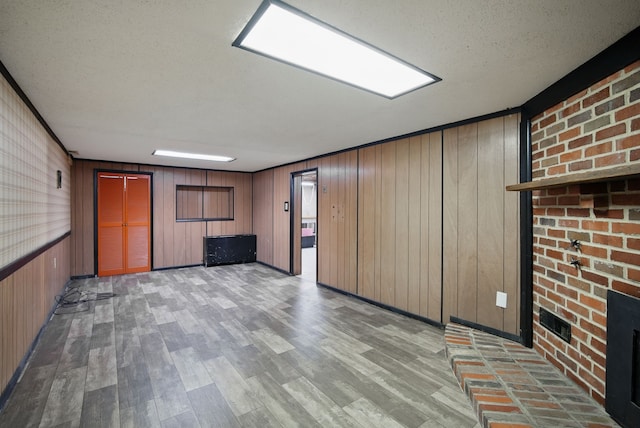 7105 Madison Ave, Urbandale, IA 50322 - unfurnished room featuring wood finished floors, wood walls, and a textured ceiling