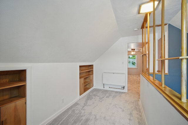 7105 Madison Ave, Urbandale, IA 50322 - bonus room featuring built in shelves, vaulted ceiling, light colored carpet, baseboards, and heating unit