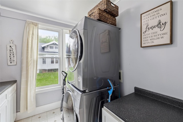 2419 30th St, Des Moines, IA 50310 - laundry area featuring estacked washer and dryer and cabinet space