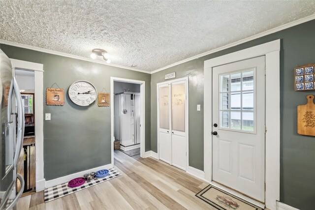 2419 30th St, Des Moines, IA 50310 - entryway with crown molding, light wood-style flooring, baseboards, and a textured ceiling