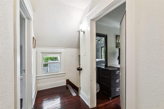 2419 30th St, Des Moines, IA 50310 - hallway with wood-type flooring, baseboards, a textured wall, and vaulted ceiling