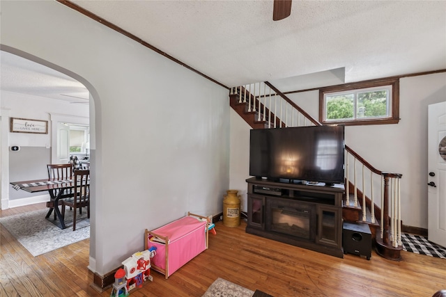 2419 30th St, Des Moines, IA 50310 - living room with stairway, wood finished floors, arched walkways, a ceiling fan, and a textured ceiling