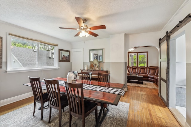 2419 30th St, Des Moines, IA 50310 - dining space featuring arched walkways, plenty of natural light, a ceiling fan, light wood-type flooring, and a textured ceiling