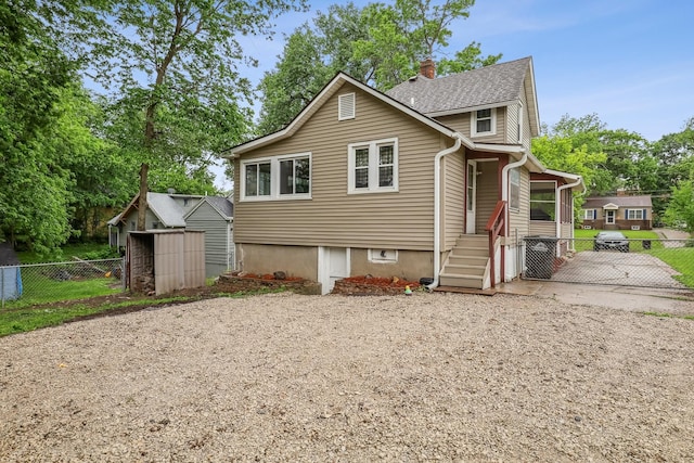 2419 30th St, Des Moines, IA 50310 - view of front of house with a chimney, a gate, and roof with shingles