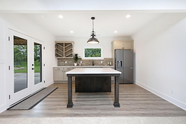 8019 NW 106th Ct, Johnston, IA 50131 - kitchen featuring stainless steel fridge with ice dispenser, light countertops, healthy amount of natural light, backsplash, and recessed lighting