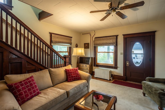 509 2nd Ave, Slater, IA 50244 - living room with radiator, carpet floors, stairway, and a ceiling fan