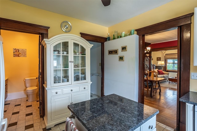 509 2nd Ave, Slater, IA 50244 - kitchen featuring a center island, white cabinets, dark stone countertops, and baseboards
