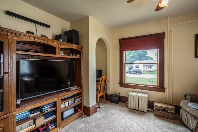 509 2nd Ave, Slater, IA 50244 - carpeted living room with radiator heating unit, ceiling fan, arched walkways, and baseboards