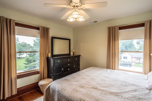 509 2nd Ave, Slater, IA 50244 - bedroom featuring multiple windows, dark wood-style floors, a ceiling fan, and baseboards