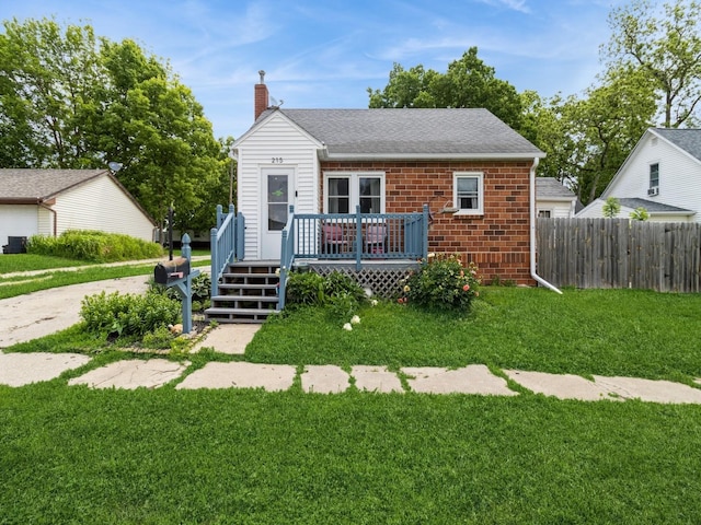 215 S 2nd St, Winterset, IA 50273 - bungalow-style home featuring a deck, a chimney, brick siding, and a shingled roof