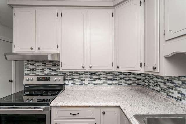 3426 N Union St, Des Moines, IA 50316 - kitchen with electric stove, under cabinet range hood, tasteful backsplash, and white cabinets