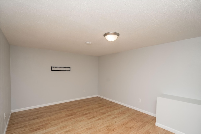 3426 N Union St, Des Moines, IA 50316 - empty room with light wood-style floors, baseboards, and a smoke detector