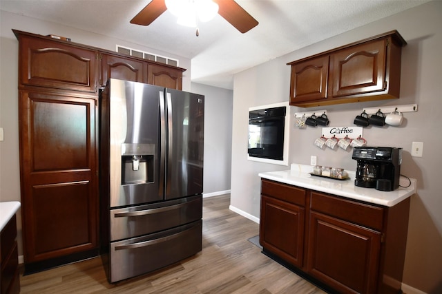 310 Fleming Rd, Carlisle, IA 50047 - kitchen featuring stainless steel refrigerator with ice dispenser, black oven, a ceiling fan, and light countertops