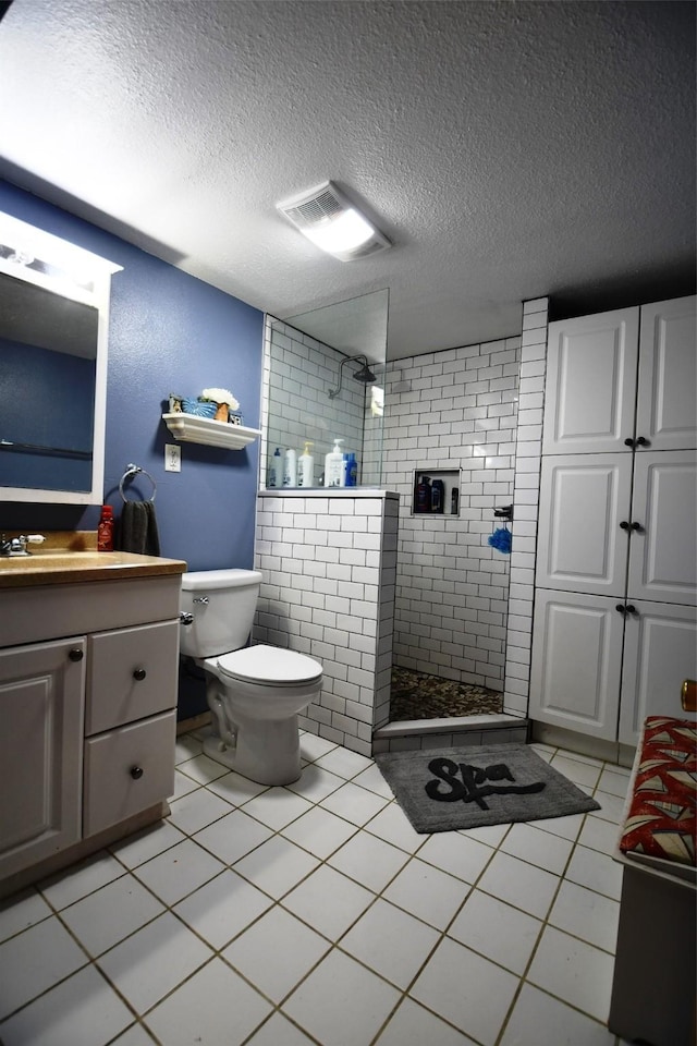 310 Fleming Rd, Carlisle, IA 50047 - bathroom featuring vanity, a textured ceiling, a walk in shower, toilet, and tile patterned floors
