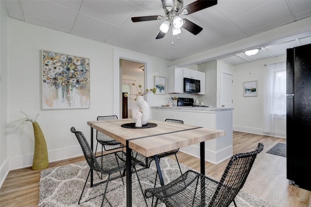 2403 E 14th St, Des Moines, IA 50316 - dining space featuring light wood finished floors, baseboards, a ceiling fan, and a drop ceiling