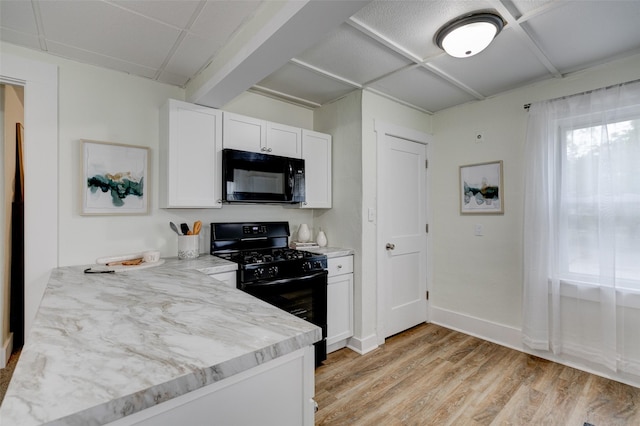 2403 E 14th St, Des Moines, IA 50316 - kitchen featuring black appliances, light wood-style floors, white cabinetry, and baseboards