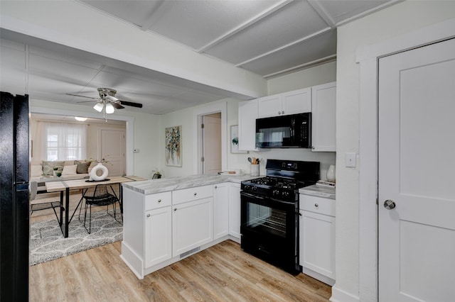 2403 E 14th St, Des Moines, IA 50316 - kitchen featuring black appliances, a peninsula, white cabinetry, and light wood-style flooring
