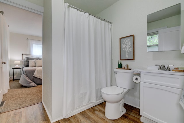 2403 E 14th St, Des Moines, IA 50316 - full bath with wood finished floors, toilet, vanity, and healthy amount of natural light
