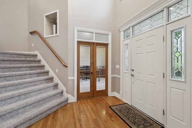 6909 Capitol View Ct, Johnston, IA 50131 - entrance foyer with french doors, light wood-style floors, stairs, and baseboards