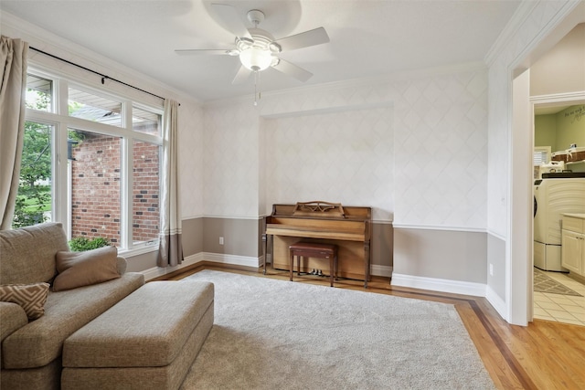 6909 Capitol View Ct, Johnston, IA 50131 - living area with ornamental molding, wood finished floors, ceiling fan, washer / dryer, and baseboards