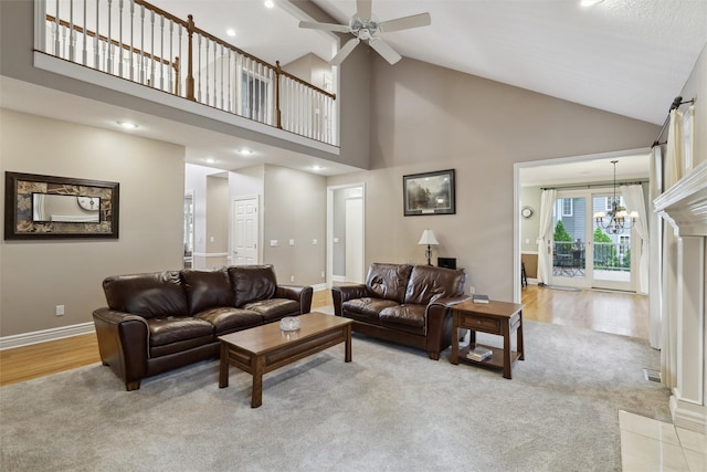 6909 Capitol View Ct, Johnston, IA 50131 - living room featuring high vaulted ceiling, a ceiling fan, light carpet, baseboards, and a chandelier