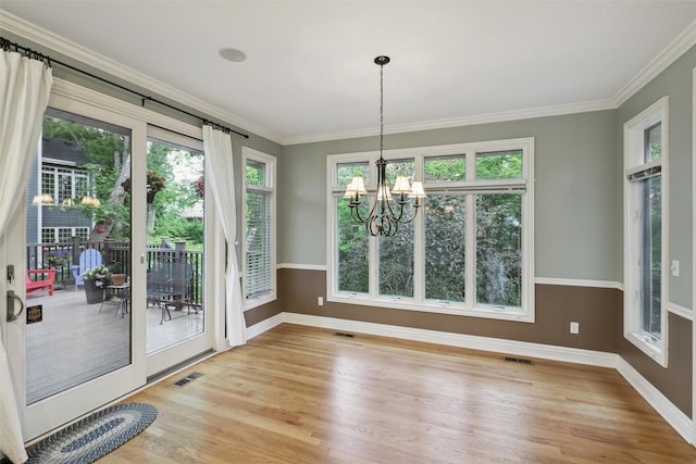 6909 Capitol View Ct, Johnston, IA 50131 - unfurnished dining area featuring baseboards, a chandelier, light wood-style flooring, plenty of natural light, and ornamental molding