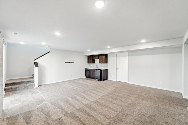 580 NW Rosemont Dr, Waukee, IA 50263 - finished below grade area with light colored carpet, recessed lighting, wine cooler, bar with sink, and stairs
