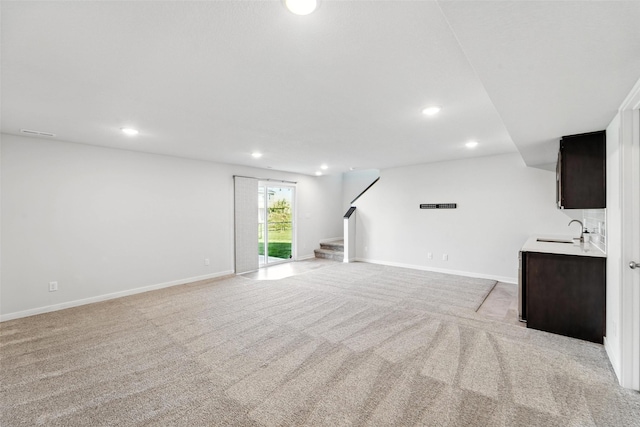 580 NW Rosemont Dr, Waukee, IA 50263 - unfurnished living room featuring light colored carpet, stairway, and recessed lighting
