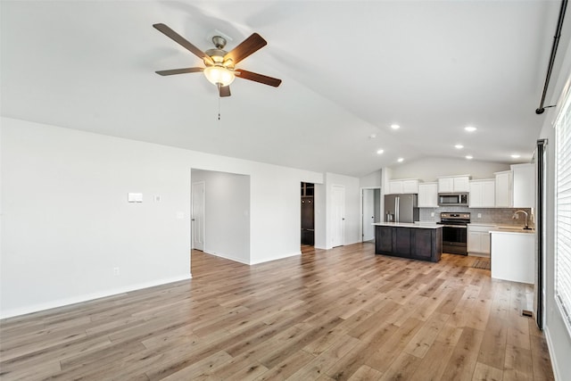 580 NW Rosemont Dr, Waukee, IA 50263 - unfurnished living room featuring lofted ceiling, a ceiling fan, light wood-style floors, and recessed lighting