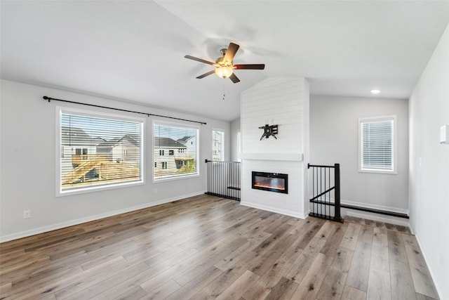 580 NW Rosemont Dr, Waukee, IA 50263 - unfurnished living room with ceiling fan, vaulted ceiling, wood finished floors, and a large fireplace