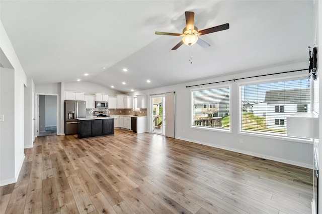 580 NW Rosemont Dr, Waukee, IA 50263 - unfurnished living room featuring vaulted ceiling, ceiling fan, light wood-style flooring, and recessed lighting