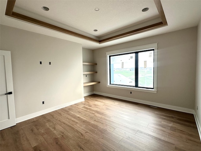 1405 NW Bull Run Ct, Waukee, IA 50263 - spare room with a raised ceiling, wood finished floors, and built in shelves