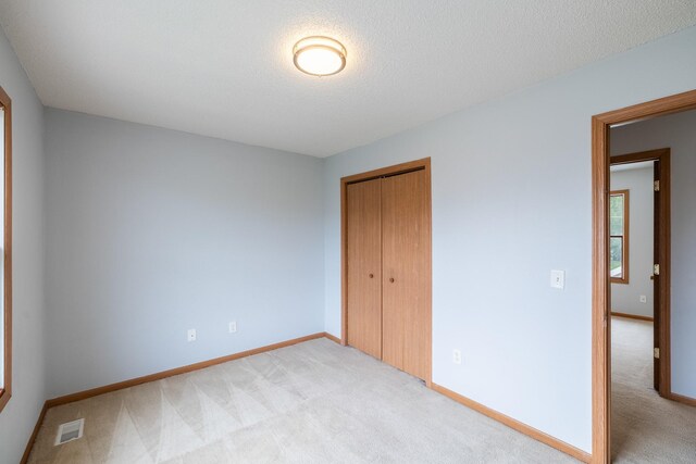 1540 8th St, Des Moines, IA 50314 - unfurnished bedroom with light colored carpet and a closet