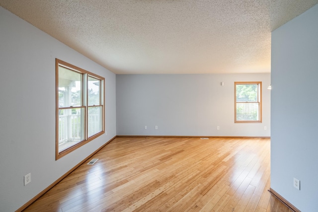 1540 8th St, Des Moines, IA 50314 - unfurnished room with a textured ceiling and light wood finished floors