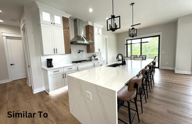 1410 NW Bull Run Ct, Waukee, IA 50263 - kitchen featuring wall chimney range hood, a sink, stainless steel gas stovetop, recessed lighting, and baseboards