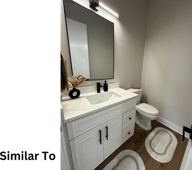 1410 NW Bull Run Ct, Waukee, IA 50263 - bathroom featuring toilet, vanity, wood finished floors, and baseboards