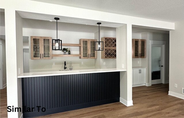 1410 NW Bull Run Ct, Waukee, IA 50263 - indoor wet bar featuring dark wood-style floors, pendant lighting, and baseboards