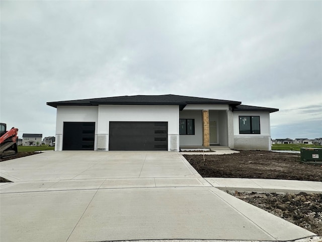1410 NW Bull Run Ct, Waukee, IA 50263 - view of front of home featuring a garage, concrete driveway, and stucco siding