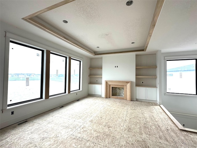 1410 NW Bull Run Ct, Waukee, IA 50263 - unfurnished living room featuring a raised ceiling and a textured ceiling