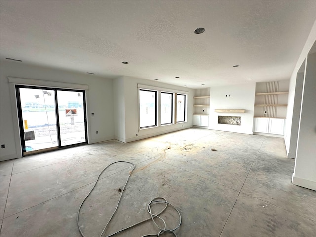 1410 NW Bull Run Ct, Waukee, IA 50263 - unfurnished living room with a textured ceiling, baseboards, and built in shelves