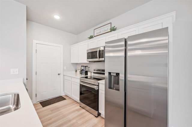 714 Umbra Pl, Norwalk, IA 50211 - kitchen featuring appliances with stainless steel finishes, light wood-type flooring, white cabinetry, light countertops, and recessed lighting