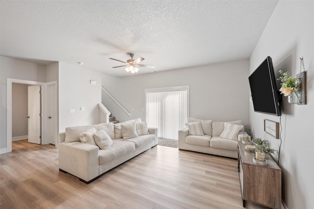 714 Umbra Pl, Norwalk, IA 50211 - living room featuring stairway, a textured ceiling, light wood finished floors, ceiling fan, and baseboards
