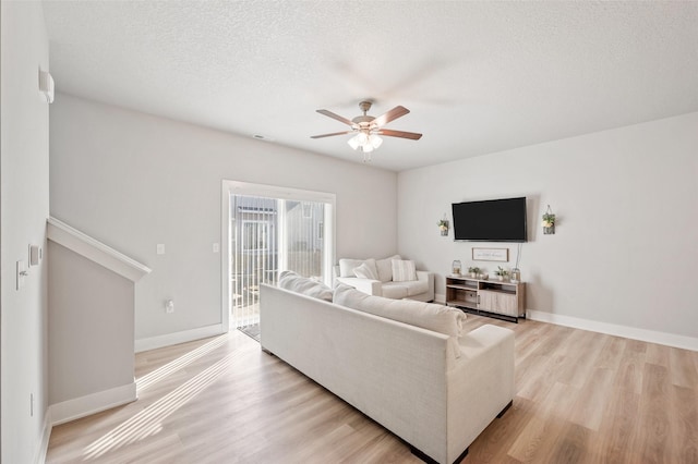 714 Umbra Pl, Norwalk, IA 50211 - living room featuring ceiling fan, light wood-type flooring, baseboards, and a textured ceiling