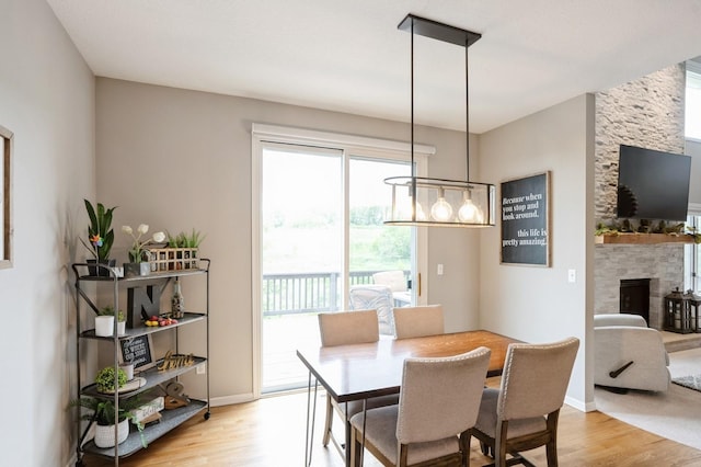 1625 S 50th Pl, West Des Moines, IA 50265 - dining space with light wood-type flooring, a fireplace, and baseboards
