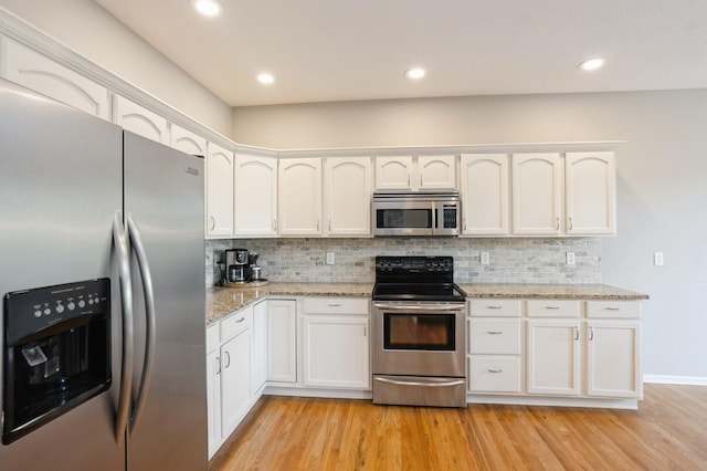 1625 S 50th Pl, West Des Moines, IA 50265 - kitchen featuring stainless steel appliances, light wood-style flooring, white cabinetry, backsplash, and recessed lighting