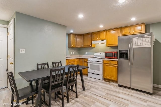 201 Main St, New Virginia, IA 50210 - kitchen featuring stainless steel fridge with ice dispenser, gas range gas stove, under cabinet range hood, light wood-type flooring, and recessed lighting