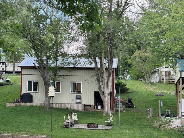 3170 Morman Trl, Ellston, IA 50074 - back of property with an outdoor fire pit, a yard, and metal roof