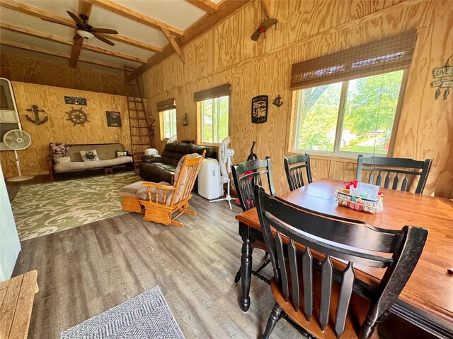 3170 Morman Trl, Ellston, IA 50074 - dining area featuring wood finished floors, wood walls, beam ceiling, ceiling fan, and high vaulted ceiling
