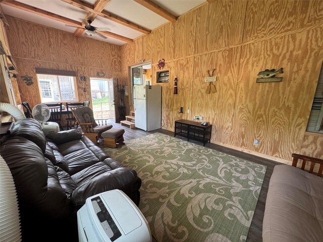 3170 Morman Trl, Ellston, IA 50074 - living area featuring beam ceiling, wood walls, a ceiling fan, wood finished floors, and baseboards